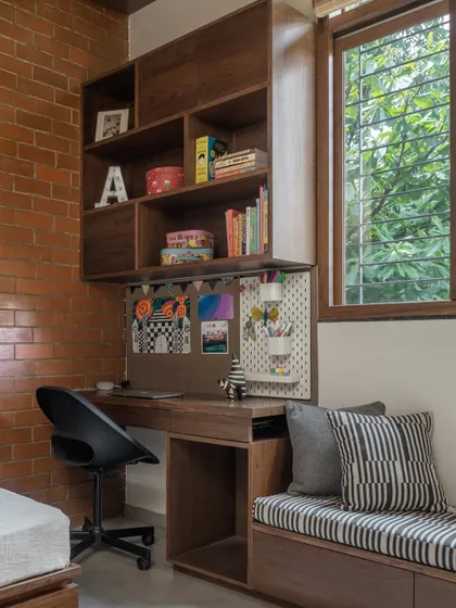 A detail of the study nook, with a pegboard for organizing stationery and a view of the trees outside.