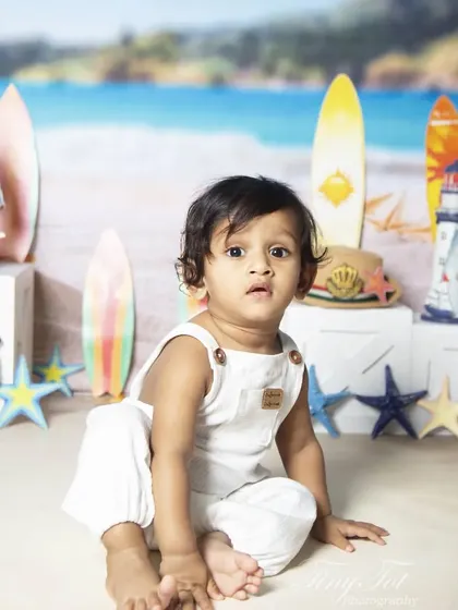 An adorable, curious look from a baby during the beach-themed sitter session.
