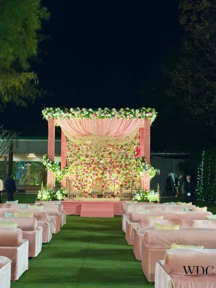 Imagine taking your vows at this surreal floral mandap. The stage is a cascade of pink and white flowers, creating a dreamy and romantic setting for a 'Floral Serene Grandeur' wedding.