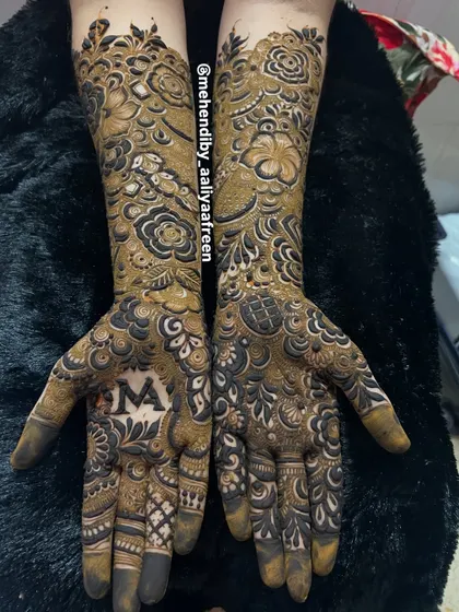 A different view of the intricate bridal mehendi, showing the beautiful flow of the design from the palm to the forearm.