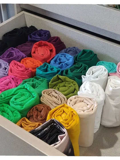 A drawer full of beautifully rolled leggings and underskirts, organized by color. This technique prevents wrinkles and allows you to see every single option you have.