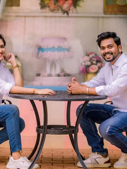A sweet and casual moment at a cafe-style table. The couple's matching white shirts and jeans create a classic, coordinated look.