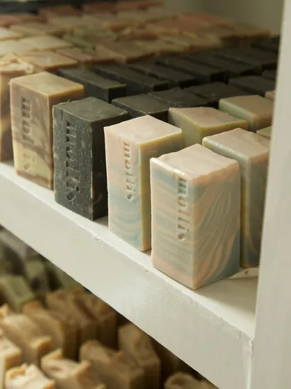 A close-up of the curing rack, showing the variety of soaps I have in stock, from the dark Oudh Charcoal to the pastel Aqua bars.