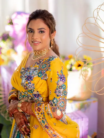 This portrait shows how the makeup beautifully complements the intricate embroidery of the haldi outfit.
