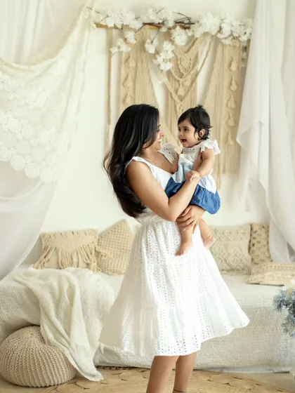 A duplicate of image 8, capturing a mother and daughter's joyful dance. The light and airy studio setting enhances the feeling of happiness and freedom.