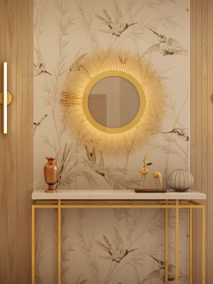 This foyer design combines a beautiful bird-patterned wallpaper with a statement sunburst mirror. The gold console table and modern wall sconces create a harmonious balance of warm and rich textures.