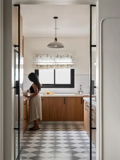 Sleek black-framed pocket doors allow the kitchen to be closed off from the dining area when needed. This design provides flexibility for an open or closed plan.