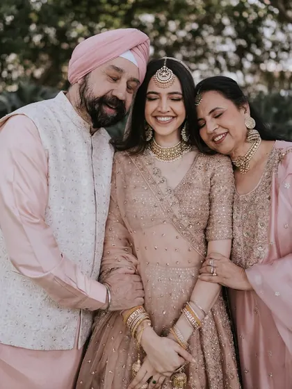 A heartwarming moment captured between the bride and her parents, full of love and emotion.