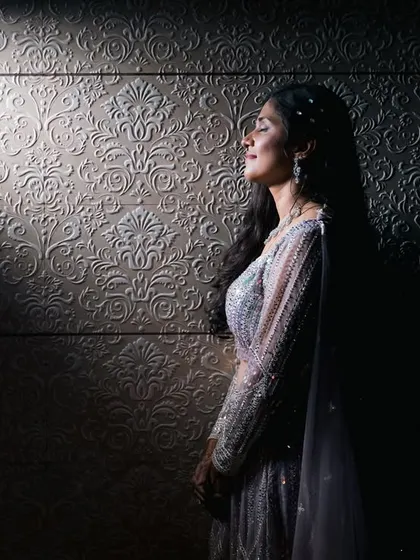 We love playing with light to create something dramatic and different. This artistic bridal portrait uses a single beam of light to highlight the bride's serene expression and the beautiful texture of her gown.