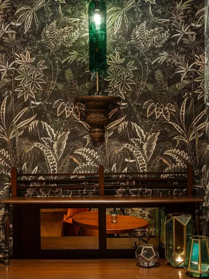 An artfully designed waiting area, where intricate wallpaper and unique lighting fixtures set the tone for the dining experience to come.