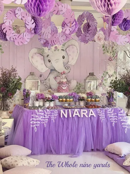 A sweet lavender elephant-themed birthday. The decor featured a custom backdrop with a baby elephant, a tulle table skirt, and low seating for the little guests.