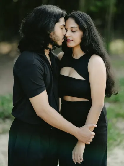 An intimate and romantic close-up of a couple in black, their faces close together in a tender moment.