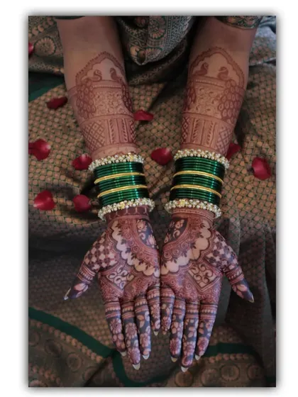 A beautiful shot of a bride's hands, adorned with green bangles that perfectly complement her mehendi. This photo was taken by a professional photographer, capturing the art beautifully.