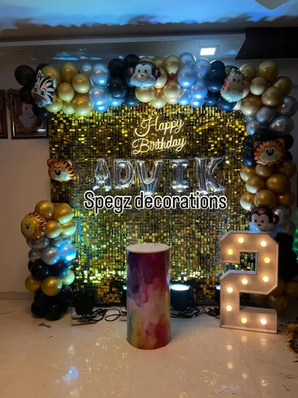A fun jungle animal theme for a second birthday. This setup uses a gold shimmer wall as a backdrop, with cute animal foil balloons and a large marquee number '2'.
