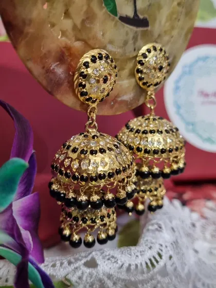 Another angle of the stunning "Kajal" Jhumkas. The contrast between the black beads and the gold plating makes these earrings a striking accessory for any special occasion.