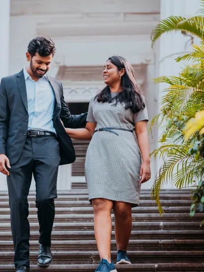 A natural shot of a couple walking down the steps of a classic building, capturing a simple, happy moment together.