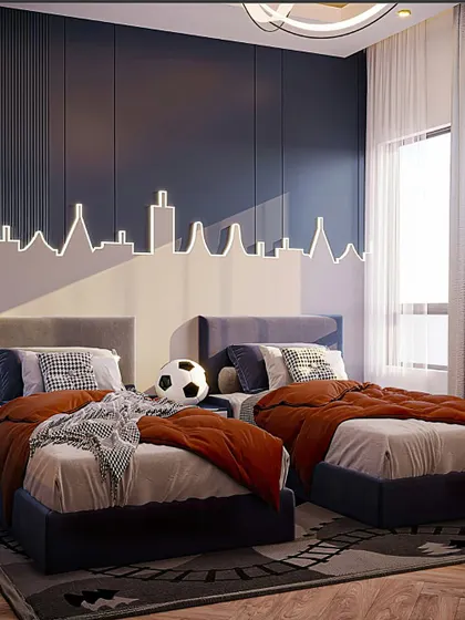 This modern twin bedroom features a cool LED light fixture in the shape of a city skyline above the beds. The deep blue accent wall and warm terracotta bedding create a stylish contrast.