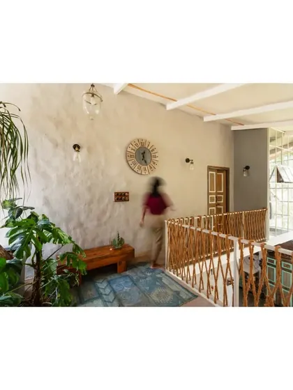 A person walking along the mezzanine, giving a sense of scale and movement to the dynamic, multi-level home.