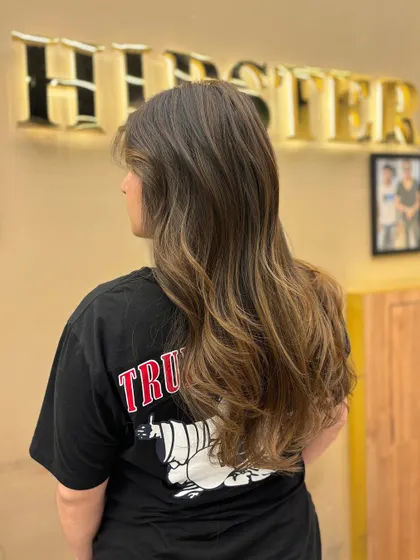 A side view of long, beautifully colored hair. The blend of tones is perfect for a client wanting a vibrant yet natural look.