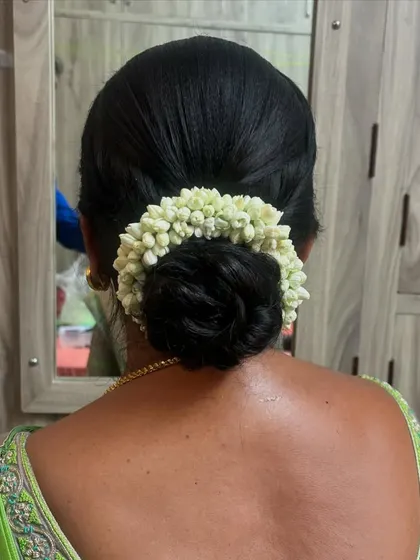 A simple and classic donut bun wrapped neatly with a fresh jasmine gajra. This style is timeless and suits any traditional attire.