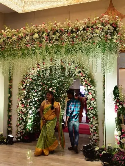A stunning floral entrance tunnel for a wedding. Guests walk through this beautiful passage of flowers, making for a grand and memorable arrival experience.