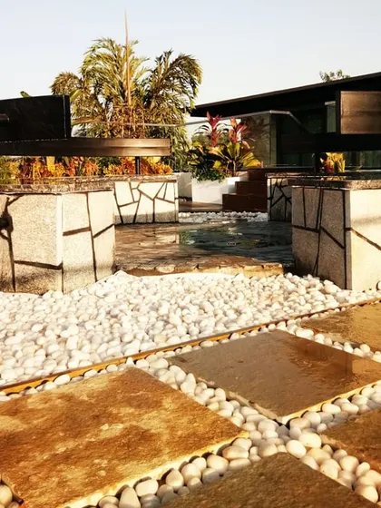 A closer look at the natural stone seating arrangement on the terrace. The combination of stone, wood, and white pebbles creates a sophisticated, multi-textured surface that is both visually striking and durable.