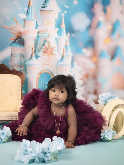 A floor-level shot from our 'Frozen' themed first birthday session. The little girl is crawling towards the camera in her beautiful dress, with the magical castle in the background.