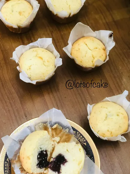 Freshly baked blueberry muffins, with one broken open to reveal the juicy blueberry filling inside. They are so soft and perfect for breakfast or a snack.
