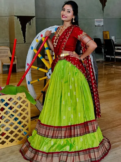 A full-length pose showing the complete look with the colourful cartwheel prop. It’s all about celebrating our culture.