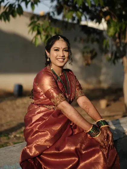 A beautiful outdoor shot of Sumana for her Varapooje. The natural light shows how the subtle makeup enhances her features without looking overpowering, perfect for daytime events.