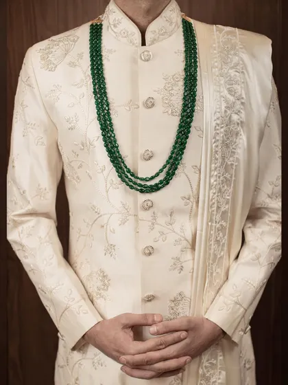 The details make the difference. This close-up shows the texture of the fabric and the precision of the tonal embroidery on our classic ivory sherwani, a hallmark of our bespoke tailoring.