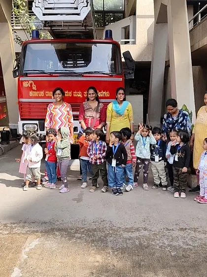 Our entire group poses proudly in front of a fire truck. These community outings help children understand the world around them and the important roles people play in it.