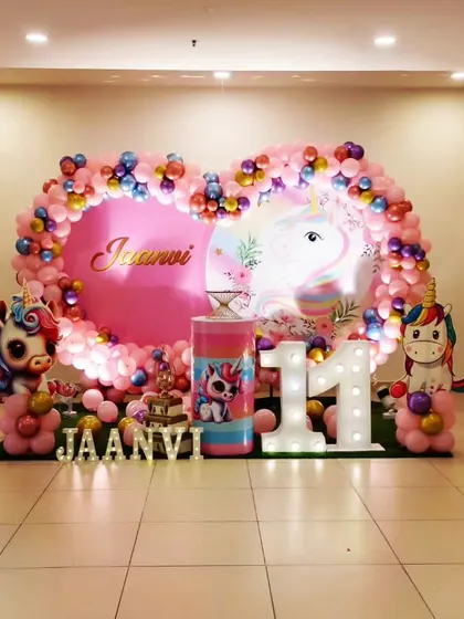 A magical unicorn theme for Jaanvi's 11th birthday. This setup features a heart-shaped balloon frame, a unicorn backdrop, and large light-up numbers, creating a dreamy and fun party atmosphere.