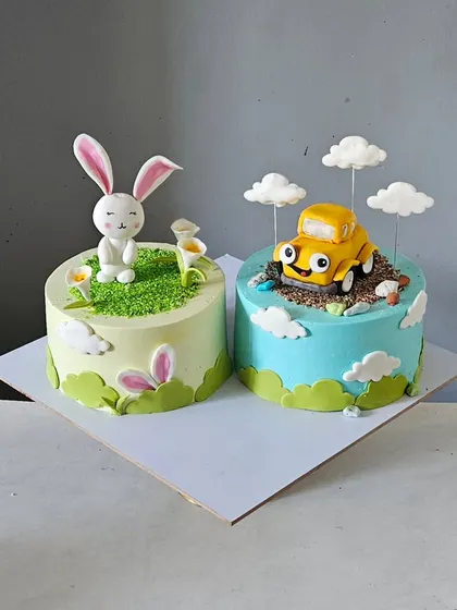 A sweet set of twin cakes, one with a bunny theme and the other with a car theme. Each cake is individually designed but coordinated, perfect for siblings who want their own special treat.
