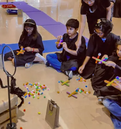 Teamwork makes the magic work. Kids collaborate on a building activity, using colorful materials to construct their own enchanted objects as part of the wizard-themed party.