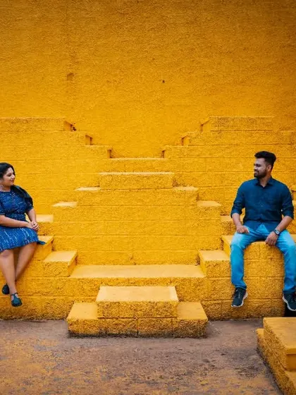 A modern and architectural pre-wedding shot. We use bold colors and strong lines, like this yellow stepwell, to create visually striking couple portraits.