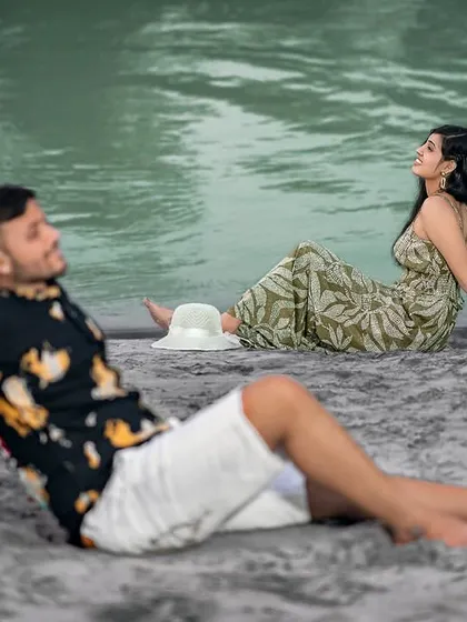 A relaxed, candid moment on the sandy shore. This shot feels natural and unposed, as if we've just captured a private moment during their riverside outing.
