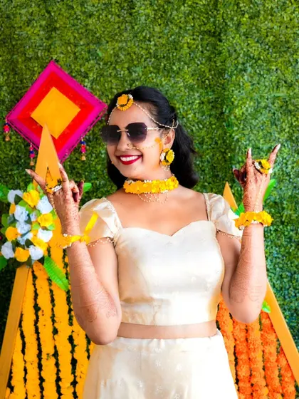 The bride showing off her fun side with a cool pose during her Haldi ceremony.