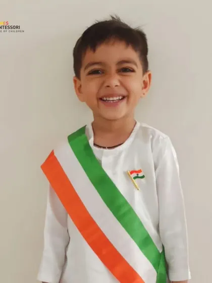 A child in a patriotic sash smiles brightly, his happiness infectious.