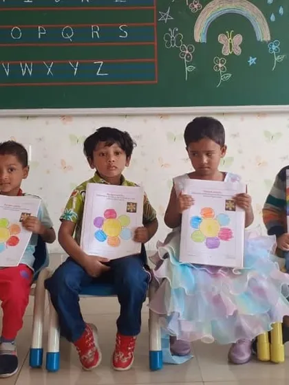 Young students proudly display their rainbow drawings, a simple yet effective way to learn about colors.