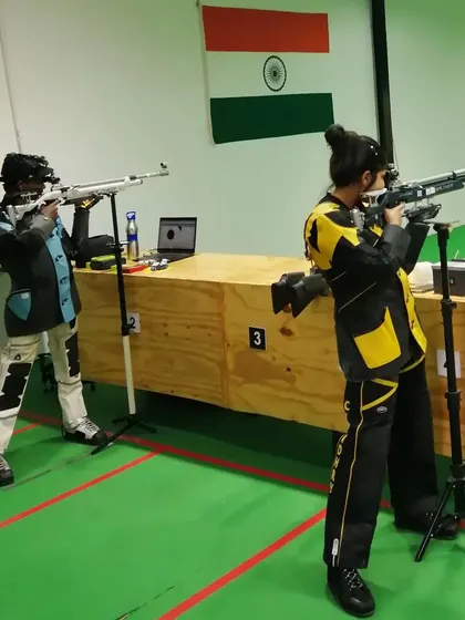 Two young female shooters in full kit during a dedicated rifle training session, preparing for their next competition.