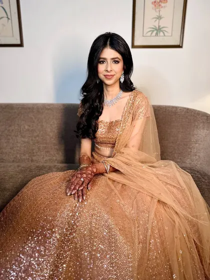A modern reception look with golden hues and effortless elegance. The soft waves and shimmering makeup create a glorious and glamorous vibe.