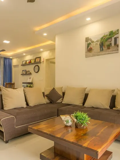 A wider view of the living area, showing the cohesive design with neutral tones and functional furniture placement.