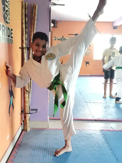 This green belt student shows off his impressive flexibility with a standing split against the wall.