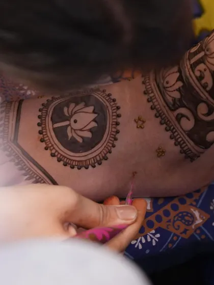 A close-up of me drawing a lotus motif. This is a moment of pure focus, ensuring every petal is perfectly shaped.