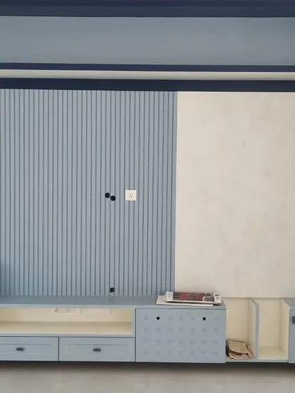 Built-in storage? Say less. Now, where do I store my motivation… and the remote I keep losing? A custom blue and white TV unit with varied textures and finishes.