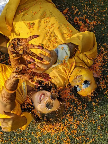 The haldi ceremony is all about unrestrained joy. This aerial shot captures the fun and playful energy of the moment, with the couple surrounded by marigold petals, lost in laughter. It’s a candid photograph that truly shows their personalities.