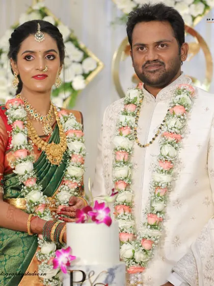 A formal portrait of the couple by their wedding cake. This classic shot captures the elegance of the reception and the beautiful details of the day.