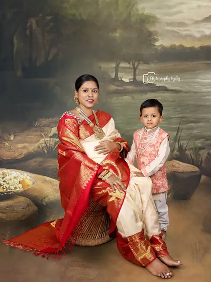 Using the same artistic, painted backdrop, this portrait captures a mother and her young son. The mother's rich red and cream saree and traditional jewelry make this a stunning example of our traditional studio maternity sessions.