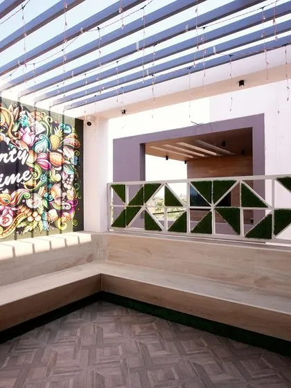 For this terrace party space, I commissioned a vibrant, graffiti-style mural to serve as an energetic backdrop. The "Party Time" artwork, combined with built-in seating, instantly defines the area's fun and social purpose.